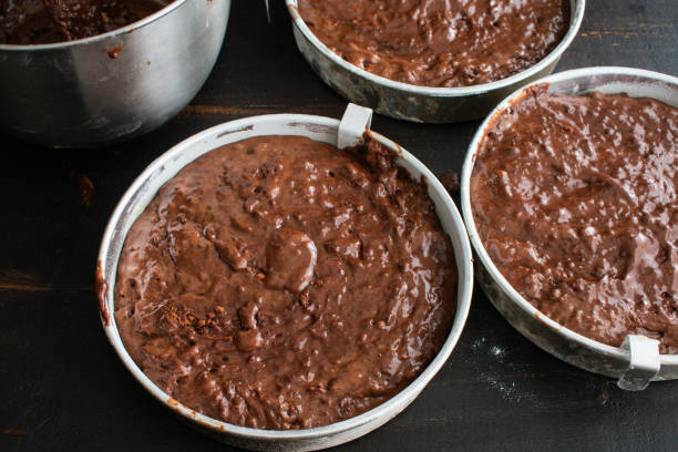 チョコレートバッターで満たされたケーキパン - baked brown cake circle ストックフォトと画像