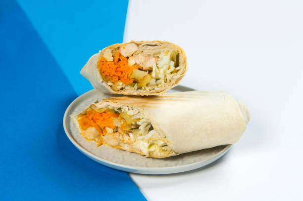 istock Chicken meat Shawarma roll wrapped in lavash bread served on blue and white abstract background 1294483138