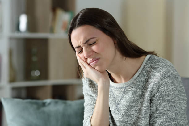 Woman complaining suffering toothache at home stock photo