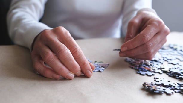 istock middle-aged woman doing puzzle for dementia. 1294486220