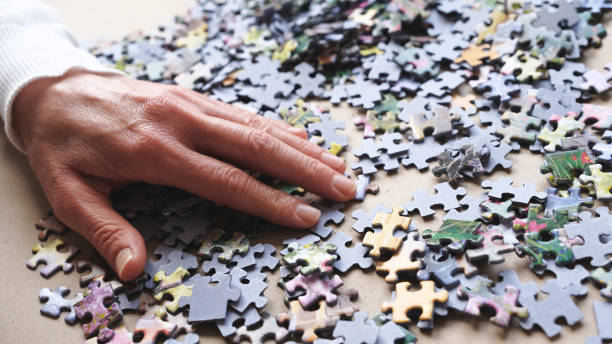 istock woman doing jigsaw puzzle at home. 1294486244