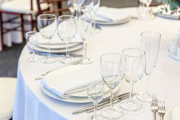 istock Fancy table set for dinner with napkin glasses in restaurant, luxury interior background. Wedding elegant banquet decoration and items for food arranged by catering service on white tablecloth table 1294486308