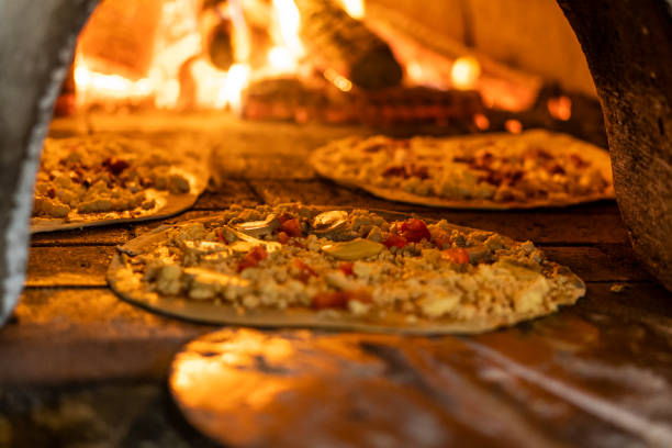 나무 오븐에 가는 피자에 닫기, 필드의 짧은 깊이 - pizzeria 뉴스 사진 이미지