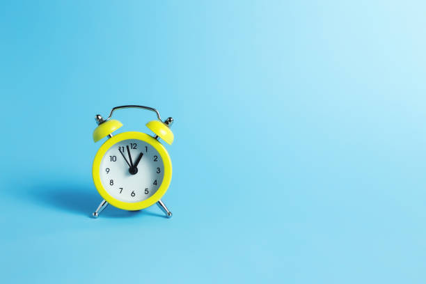 istock Mechanical alarm clock on the blue background 1294488544
