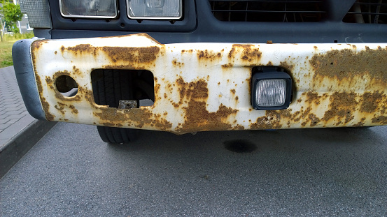 Metal corrosion of old truck. Rust hole removal and repair. Rusty messy car surface. Damaged grunge texture from road salt. Protecting automobile. Concept of Paint vehicle without welding. Service.