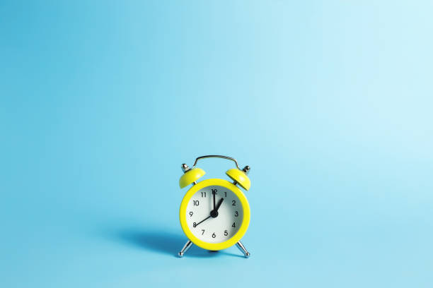 istock Mechanical alarm clock on the blue background 1294488555