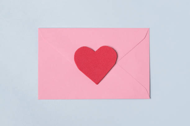 istock Pink envelope with red heart for valentine day on light blue background 1294489862