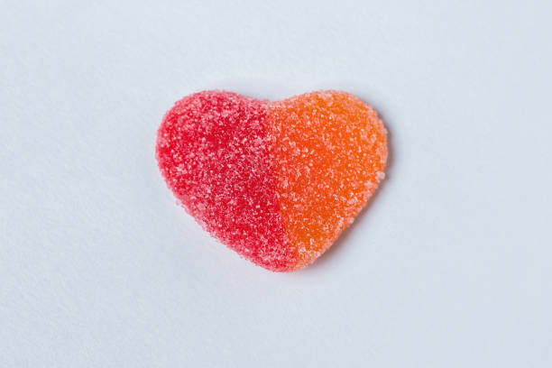 istock Red and orange gummy heart on a light blue background 1294489864