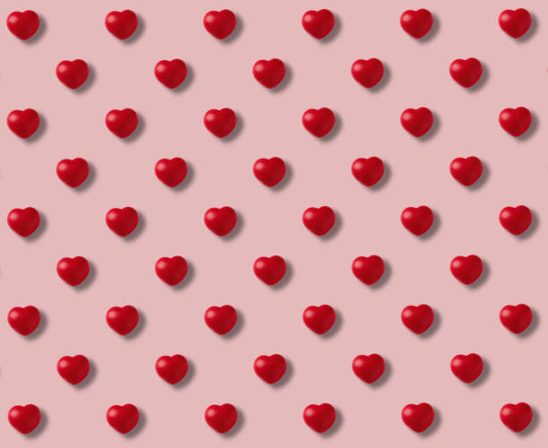 istock Pattern of red hearts on pink background 1294489896