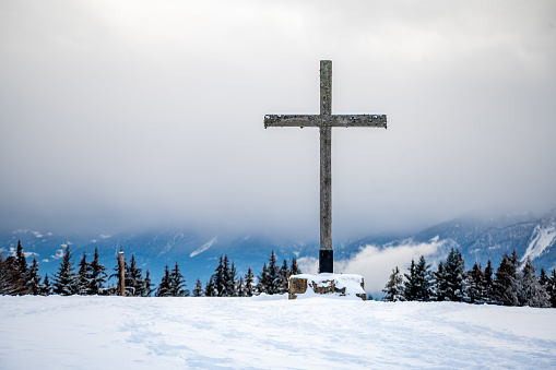 Cross in the snow. Wooden religious cross in winter. Les Pleiades, Switzerland.