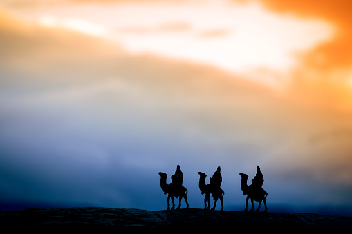 Silhouette of three wise men on camels at sunset. Representation of Christmas Nativity concept.