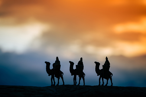 Silhouette of three wise men on camels at sunset. Representation of Christmas Nativity concept.