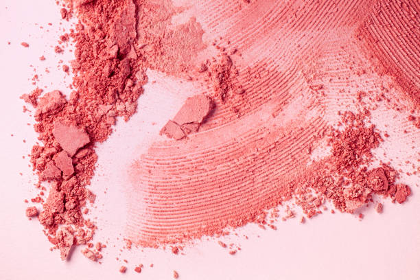 Bright coral purple pink smudged make-up gradient texture palette concealer foundation matte blusher powder on pink and black isolated background