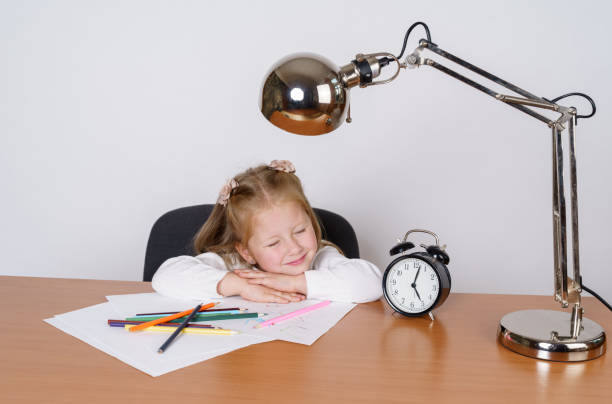 istock Girl sitting at the table, tired and sleeping.Isolated on a white background. 1294491236