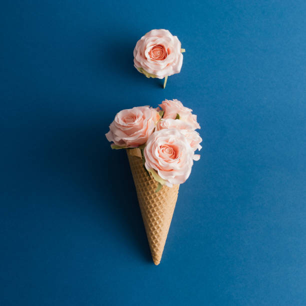 istock Rose flowers and ice cream cone on blue background. Minimal concept. Flat lay. 1294493177