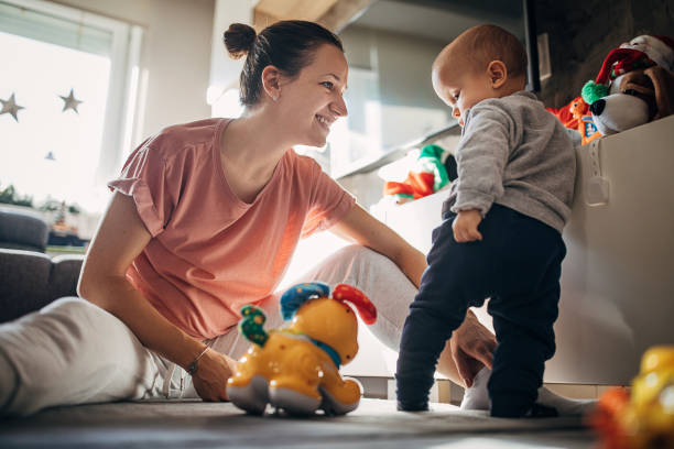 istock Mother playing with baby son on the floor 1294494358