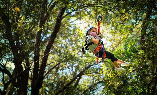 Three years old girl wearing protective mask on a zip line in Costa Rica
