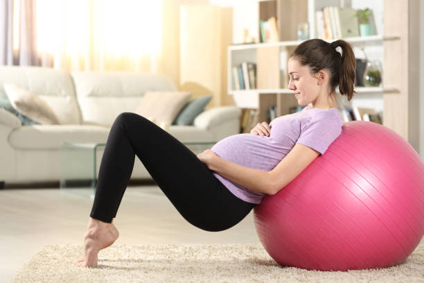 istock Pregnant woman doing exercise at home with a ball 1294500976