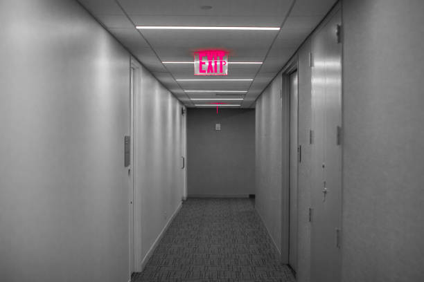 Man going exit with green emergency exit sign on wooden wall