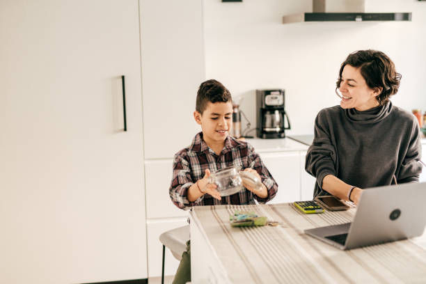 istock Saving tips. Kid counting cash in the kitchen 1294509770