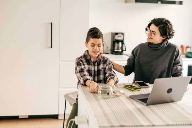 istock Mother and son in the kitchen. Boy is counting money 1294509774