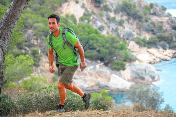 istock Fit Spanish Male Hiker Climbing Cliffside Trail 1294510591