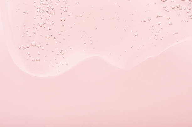 the texture of the gel, skincare serum on a pink background. a transparent liquid cosmetic with bubbles to moisturize the skin of the face and body. cleansing beauty product, scrub with natural acids - soap sud water bubble drop imagens e fotografias de stock