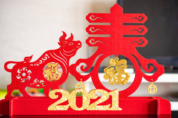 ox mascot and symbol of spring as symbol of Chinese New Year of the Ox in a living room the Chinese means spring and good luck ox mascot and symbol of spring as symbol of Chinese New Year of the Ox in a living room the Chinese means spring and good luck chinese zodiac sign photos stock pictures, royalty-free photos & images