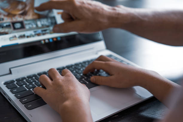 istock Young child and older man work on new laptop together 1294518444