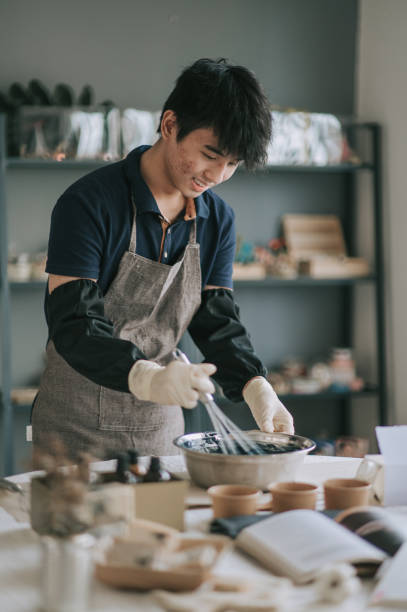 istock Asian chinese teenage boy using whisk mixing ingredient learning the soap making process from female artist 1294520162