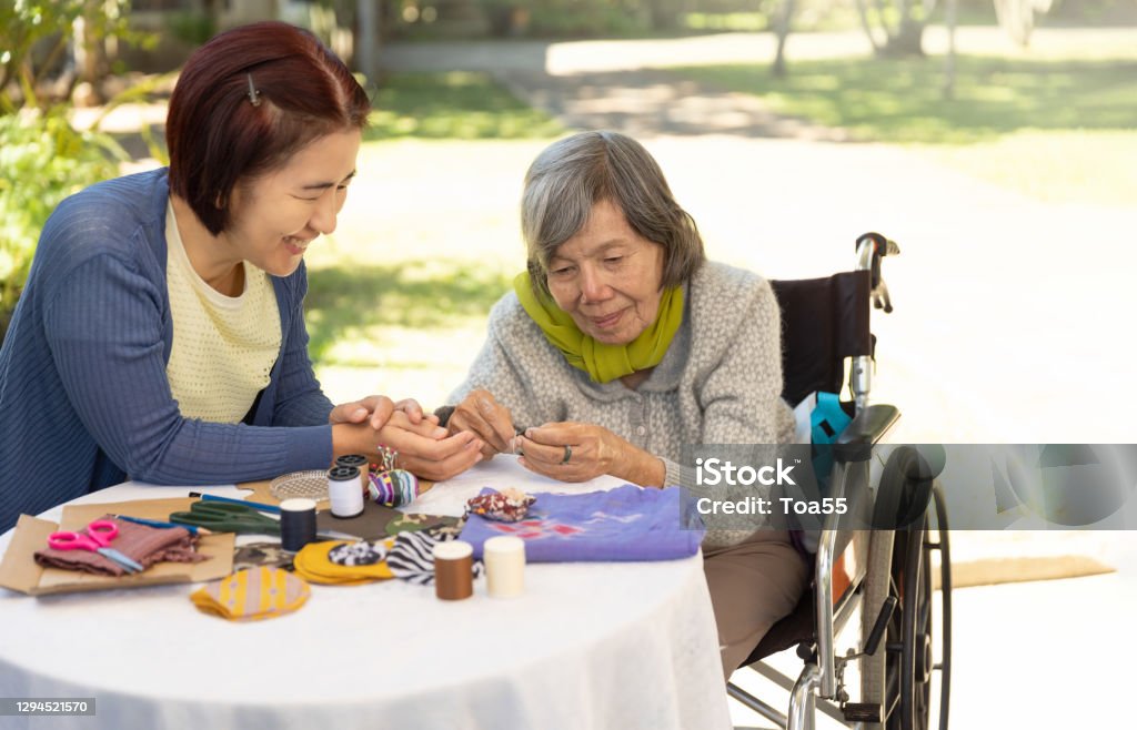 Elderly woman and daughter in the needle crafts occupational therapy for Alzheimer’s or dementia Dementia Stock Photo