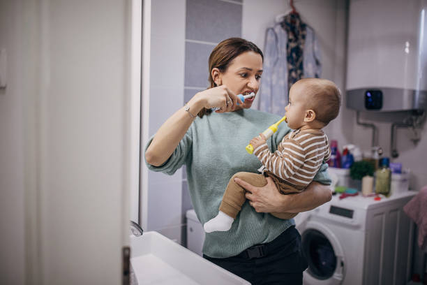 mutter lehrt ihren sohn, zähneknirschend zu putzen - human teeth child smiling family stock-fotos und bilder