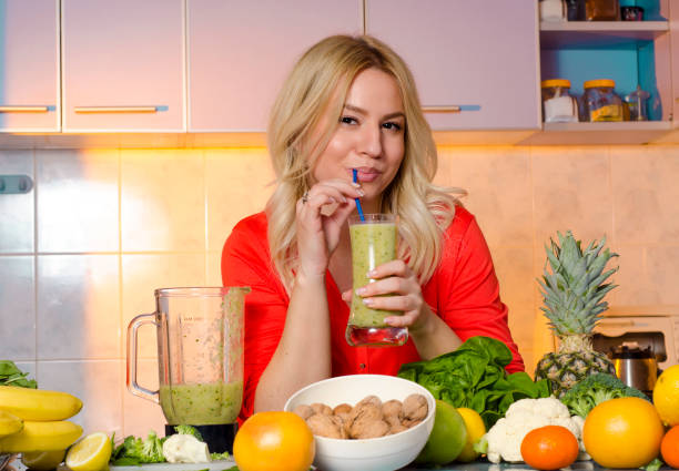 istock Gorgeous young woman drinking delicious smoothie in her kitchen 1294528260