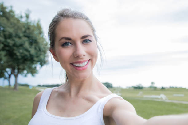 istock Beautiful woman smiles for selfie 1294529107