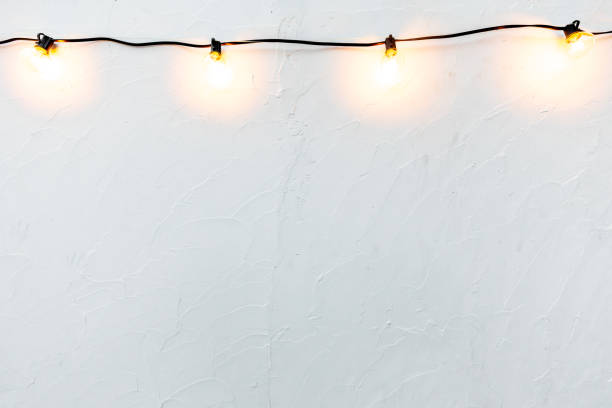 istock Luxury beautiful retro Naked hanging bulb glowing wall empty interior decoration modern warm white lamps and Whith cement wallpaper background. decorative and white wall for home office. Copy space 1294530711