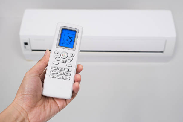 istock Man's hand using remote control open The air conditioner is cooled to 25 degrees Celsius in his bedroom. Health concepts and energy savings.soft focus 1294530773