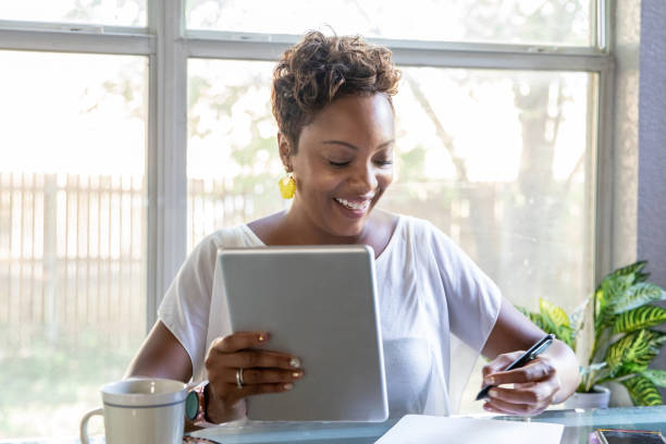 istock Businesswoman works from home while holding digital tablet and taking notes 1294533184