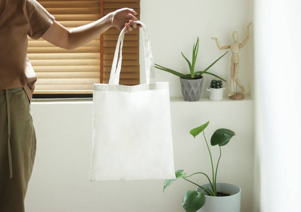 model hold blank white fabric tote bag for save environment on street fashion model hold blank white fabric tote bag for save environment on street fashion bagger stock pictures, royalty-free photos & images