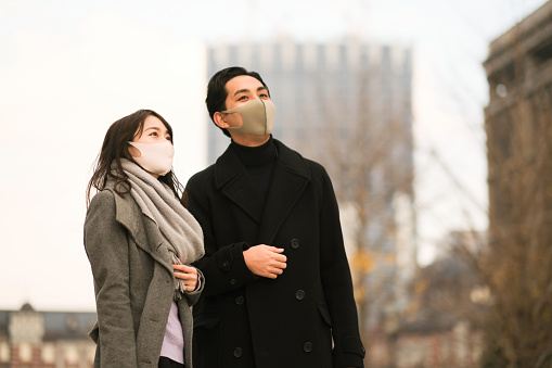 Asian couple walking on street of downtown in December