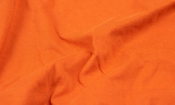 istock Orange crinkled fabric with visible details. background 1294547922