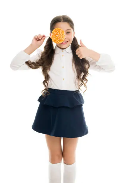 Healthy nutrition diet. Sweets reward for study. Rewarding herself with sweets. Food addictions. Girl kid eat sweet lollipop. Girl pupil school uniform like sweets lollipop candy white background.