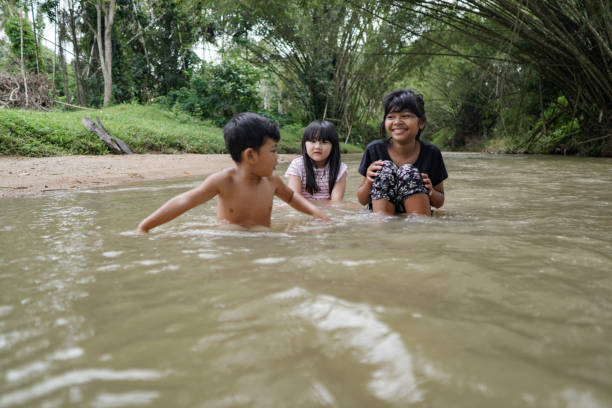 istock Cute Kids Siblings together Playing Sand pebbles at River Rural 1294550073