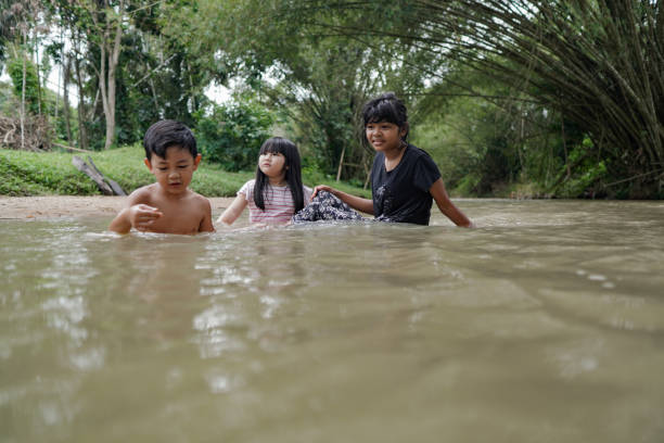 istock Cute Kids Siblings together Playing Sand pebbles at River Rural 1294550141