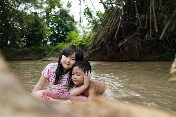 istock Cute Kids Siblings together Playing Sand pebbles at River Rural 1294550158