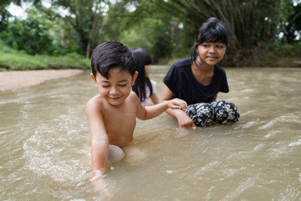 istock Cute Kids Siblings together Playing Sand pebbles at River Rural 1294550188