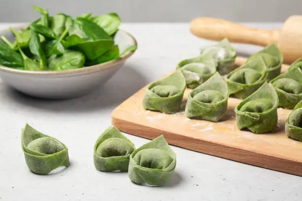 Raw Balanzoni - italian green stuffed pasta with ricotta and spinach, egg  and spinach dough. Close-up.