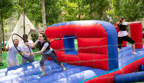 Photo of Woman collecting hoops on inflatable trampoline