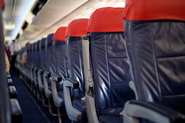 istock An aircraft cabin with empty passenger rows of seats. 1294556022