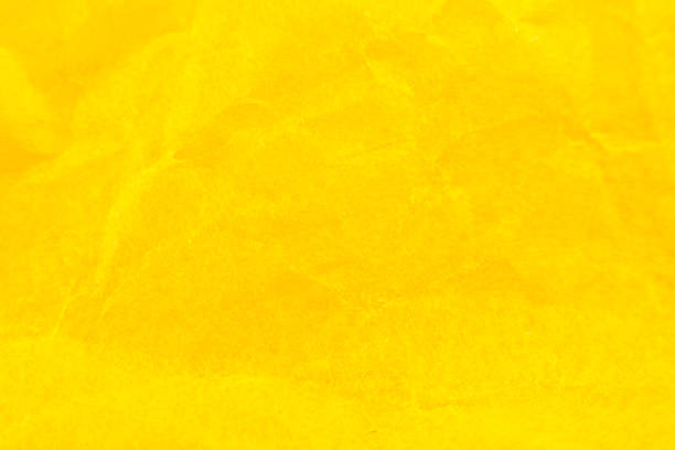 istock Crumpled yellow paper background. Real macro battered texture. Close up photo. 1294559121