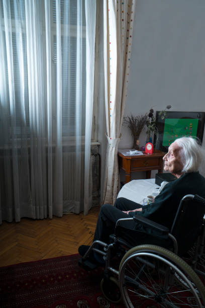 自宅で車椅子に乗った先輩女性のサイドビューの肖像画 - healthcare and medicine home interior side view vertical ストックフォトと画像